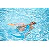 Young woman in a swimming pool performing some synchronized swimming drills