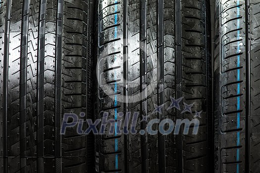 Stack of brand new high performance car tires on clean low-key black studio background Stack of brand new high performance car tires on clean low-key black studio background