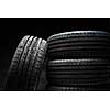Stack of brand new high performance car tires on clean low-key black studio background