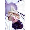 Pretty young woman tanning her skin in a modern solarium
