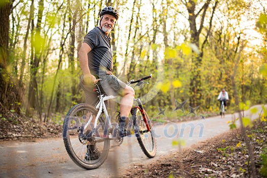 Senior man on his mountain bike outdoors (shallow DOF; color toned image) Senior man on his mountain bike outdoors (shallow DOF; color toned image)