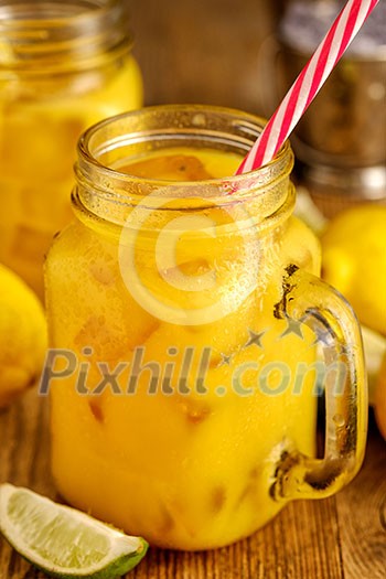 Fresh orange juice with ice in a mason jar on wooden table Fresh orange juice with ice in a mason jar on wooden table