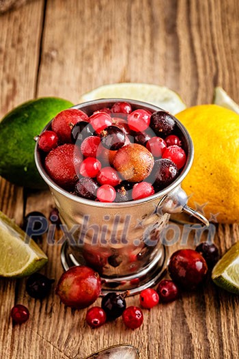 Small metal pail with different frozen berries on wooden table. Shallow depth of field. Rustic style. Small metal pail with different frozen berries on wooden table. Shallow depth of field. Rustic style.