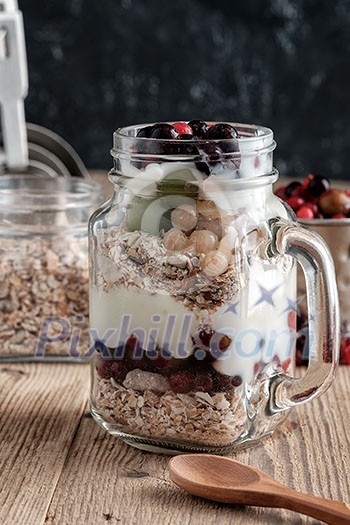 Healthy breakfast with Homemade granola. Muesli, fresh berries and yogurt in glass mason jar on wooden table. Healthy breakfast with Homemade granola. Muesli, fresh berries and yogurt in glass mason jar on wooden table.