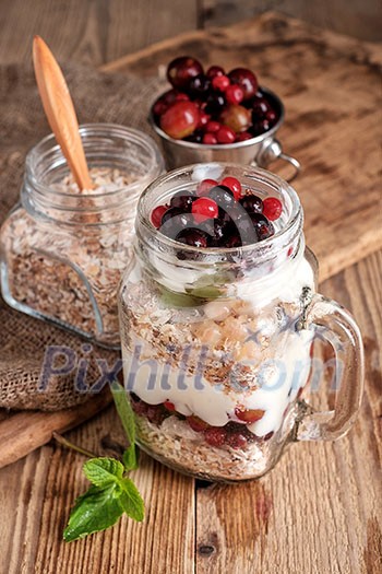 Muesli, fresh berries and yogurt in glass mason jar on wooden table. Healthy breakfast with Homemade granola Muesli, fresh berries and yogurt in glass mason jar on wooden table. Healthy breakfast with Homemade granola