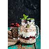 Muesli, fresh berries and yogurt in glass mason jar on wooden table. Healthy breakfast with Homemade granola