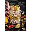 Fresh berries with ice in mason jar on dark background. Detox diet.