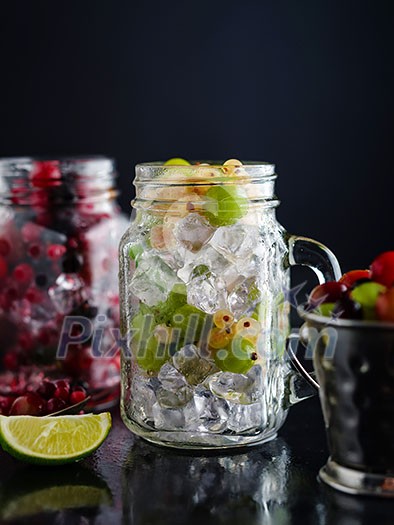 Fresh berries with ice in mason jar on dark background. Detox diet. Fresh berries with ice in mason jar on dark background. Detox diet.