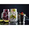 Fresh berries with ice in mason jar on dark background. Detox diet.