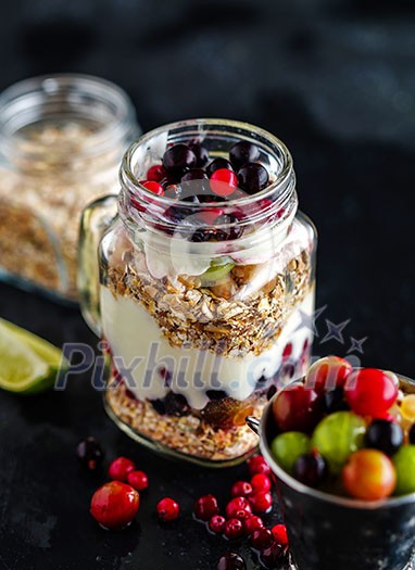 Muesli, fresh berries and yogurt in glass mason jar on wooden table. Healthy breakfast with Homemade granola Muesli, fresh berries and yogurt in glass mason jar on wooden table. Healthy breakfast with Homemade granola