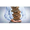 Close up of man holding pile of books in hands
