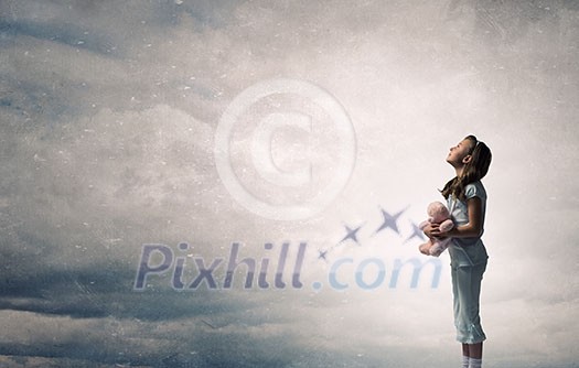 Cute girl wearing pajamas with toy bear in hand Cute girl wearing pajamas with toy bear in hand