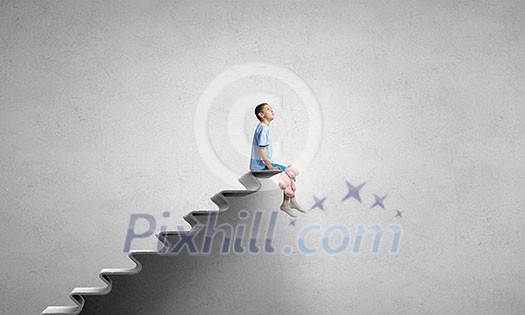 Cute little boy with toy bear sitting on ladder of books Cute little boy with toy bear sitting on ladder of books