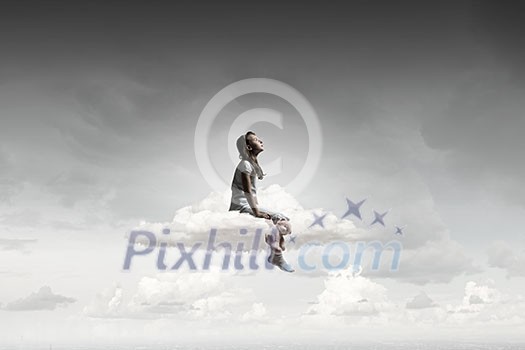 Cute girl wearing pajamas with toy bear in hand sitting on cloud