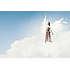 Attractive woman with angel wings on sky background