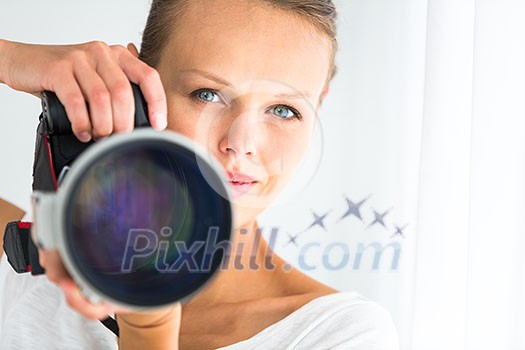 Pretty, female photographer with digital camera - DSLR and a huge telephoto lens (color toned image; shallow DOF) Pretty, female photographer with digital camera - DSLR and a huge telephoto lens (color toned image; shallow DOF)