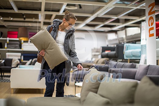 Pretty, young woman choosing the right furniture for her apartment in a modern home furnishings store (color toned image; shallow DOF) Pretty, young woman choosing the right furniture for her apartment in a modern home furnishings store (color toned image; shallow DOF)