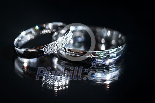 Wedding day details - two lovely golden wedding rings awaiting their moment, with some nice reflections Wedding day details - two lovely golden wedding rings awaiting their moment, with some nice reflections