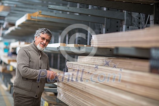 Man choosing and buying construction wood in a DIY store for his DIY home re-modeling project Man choosing and buying construction wood in a DIY store for his DIY home re-modeling project
