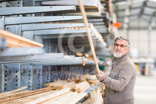 Man choosing and buying construction wood in a DIY store for his DIY home re-modeling project Man choosing and buying construction wood in a DIY store for his DIY home re-modeling project