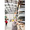 Man choosing and buying construction wood in a DIY store for his DIY home re-modeling project