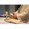 Priest during a wedding ceremony/nuptial mass (shallow DOF; color toned image)