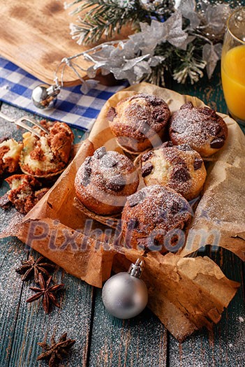 Chocolate muffins with powdered sugar on the wooden table, rustic style. New Year's Concept. Chocolate muffins with powdered sugar on the wooden table, rustic style. New Year's Concept.