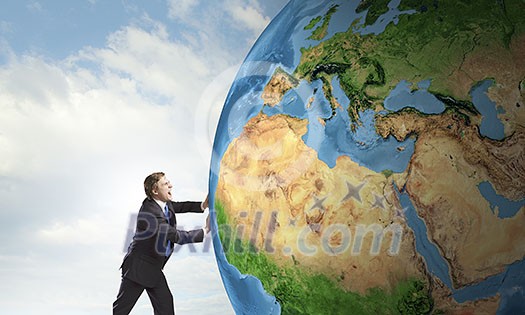Businessman pushing big Earth planet. Elements of this image are furnished by NASA Businessman pushing big Earth planet. Elements of this image are furnished by NASA