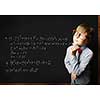 Smart boy in red glasses near blackboard with formulas