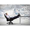 Smiling businessman sitting in chair with legs on table