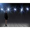 Rear view of businesswoman standing in lights of stage