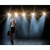 Rear view of businesswoman standing in lights of stage