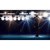 Rear view of businessman standing in lights of stage