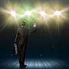 Rear view of businessman standing in lights of stage