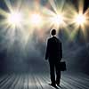 Rear view of businessman standing in lights of stage