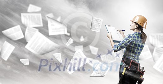 Rear view of woman engineer making some notes and sketches