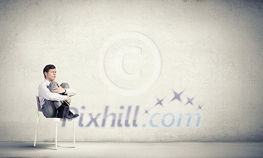Young businessman sitting in chair and relaxing Young businessman sitting in chair and relaxing