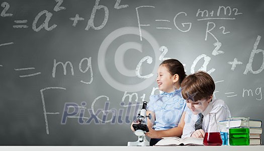 Cute girl and boy at chemistry lesson making tests Cute girl and boy at chemistry lesson making tests