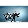 Young businessman fixing gears mechanism with wrench