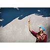 Young woman in headscarf painting wall with brush