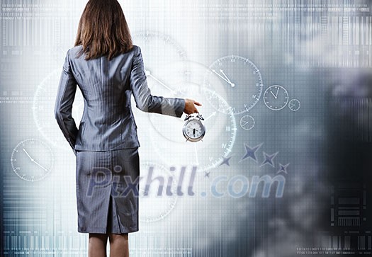 Rear view of businesswoman holding old alarm clock Rear view of businesswoman holding old alarm clock