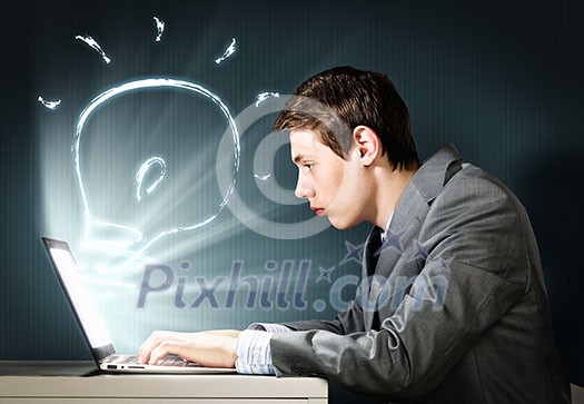 Young businessman looking shocked into laptop monitor Young businessman looking shocked into laptop monitor