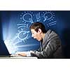 Young businessman looking shocked into laptop monitor