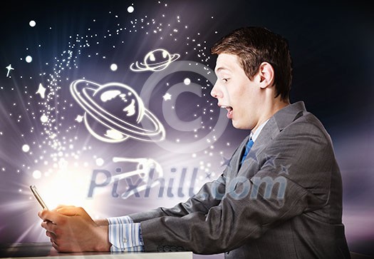 Young businessman looking shocked into tablet pc Young businessman looking shocked into tablet pc