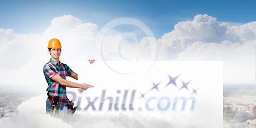 Young repairman holding white blank banner. Place for text Young repairman holding white blank banner. Place for text