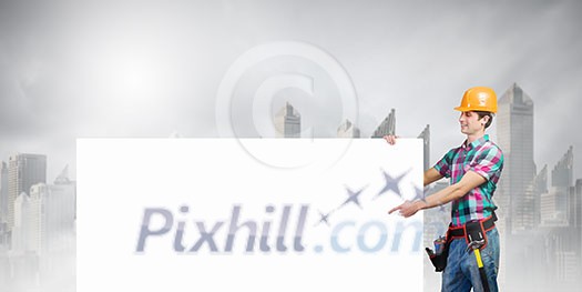 Young repairman holding white blank banner. Place for text Young repairman holding white blank banner. Place for text