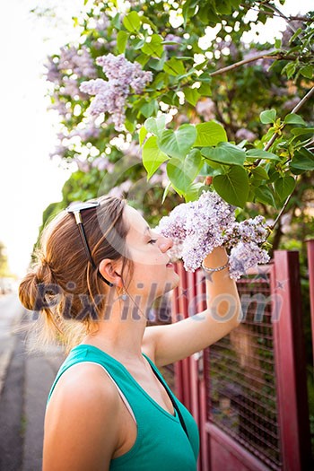 Beautiful young woman smelling white jasmin flowers Beautiful young woman smelling white jasmin flowers