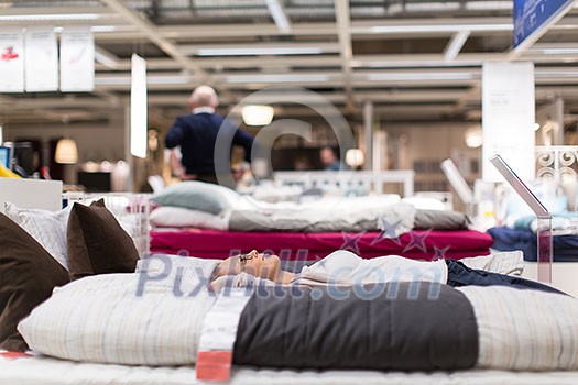 Pretty, young woman choosing the right furniture for her apartment in a modern home furnishings store (color toned image; shallow DOF) Pretty, young woman choosing the right furniture for her apartment in a modern home furnishings store (color toned image; shallow DOF)