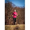 Young woman running outdoors on a lovely sunny winter/fall day