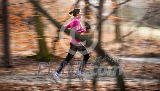 Young woman running outdoors in a city park on a cold fall/winter day (motion blurred image) Young woman running outdoors in a city park on a cold fall/winter day (motion blurred image)